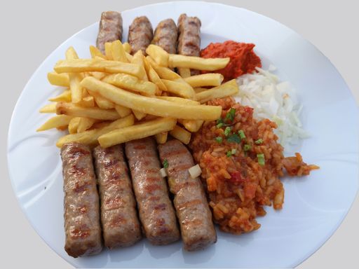 A closeup of meat and french fries accompanied by sauces
