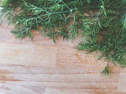 A top view of fresh dill with copy space on a wooden chopping board