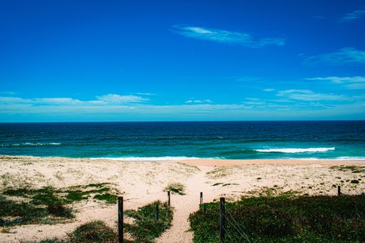 A mesmerizing shot of the turquoise sea and sandy beach under the blue sky