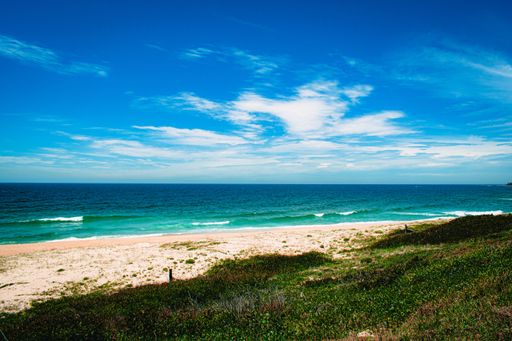 A mesmerizing shot of the turquoise sea and sandy beach under the blue sky