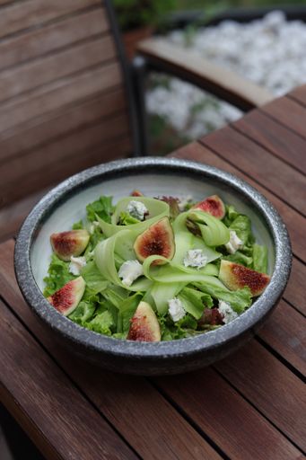 A vertical shot of fresh healthy salad with cheese and figs