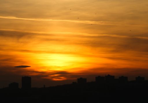 A mesmerizing sunset sky over the silhouettes of buildings