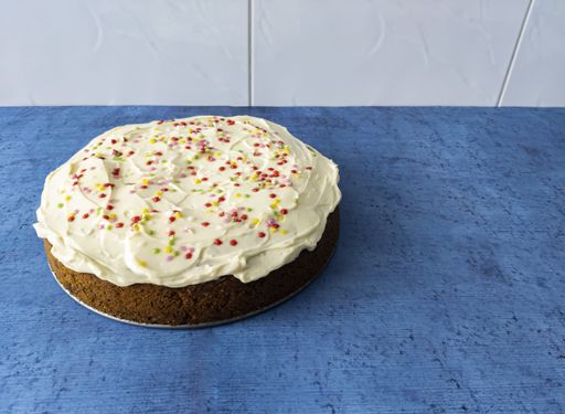 A high angle shot of a delicious carrot cake on a blue surface