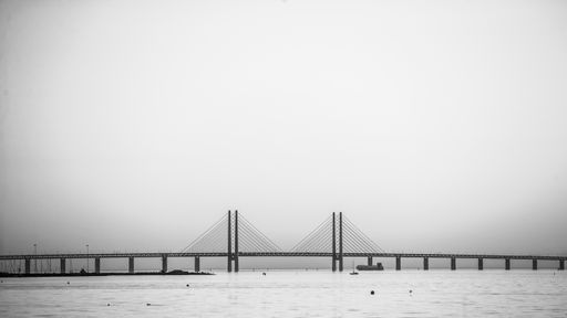 A beautiful shot of the Öresundsbron bridge over the sea with a foggy background