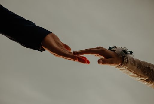 A closeup shot of the groom and the bride holding hands
