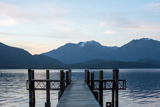 A beautiful nature scene with a wooden jetty over a calm water surface
