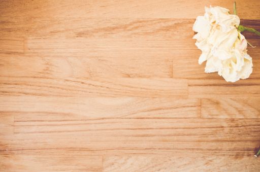 A top view of the beautiful white roses on a wooden surface