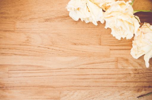 A top view closeup of white roses placed on a wooden table