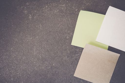 A top view of blank paper memos on a rough-textured surface with copy space
