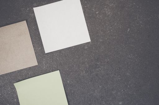 A top view of blank paper memos on a rough-textured surface with copy space