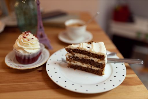 A piece of cake and a cupcake on a decorated table in a cafe