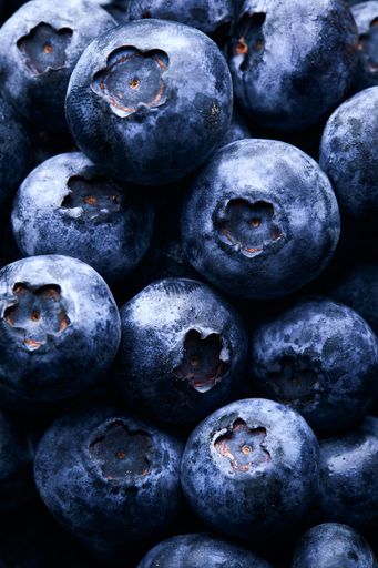A vertical closeup shot of a lot of blueberries - great for background or wallpaper
