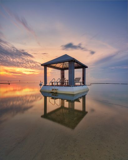 A vertical shot of a floating gazebo at Sanur beach during sunrise