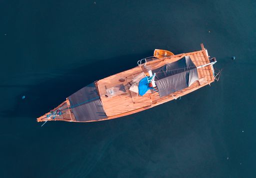 A beautiful aerial overhead shot of a boat at the sea