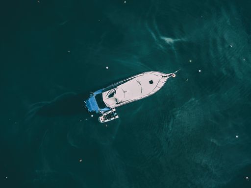 An aerial overhead shot of a boat at the sea