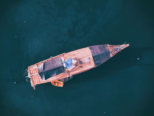 An aerial overhead shot of a boat at the sea