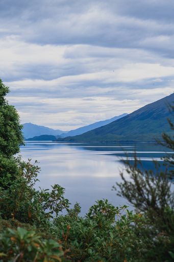 A beautiful view of the mountain chain covered in snow and a lake on a cloudy day