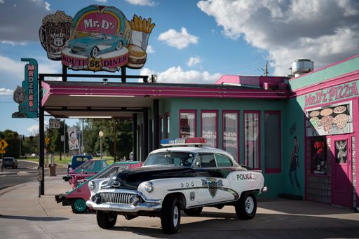 An old 1952 Buick Super Riviera Special of the police, it is raised and parked in front of a restaurant