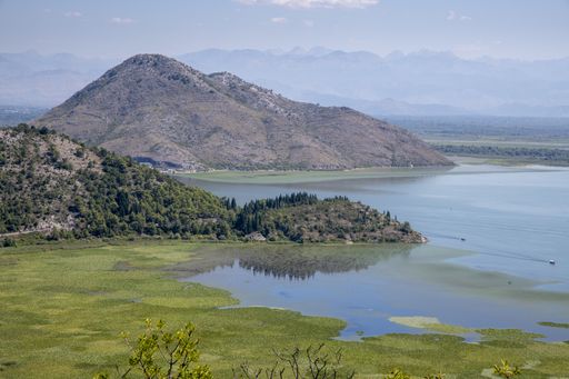 A high angle shot of the Lake Skadar near mountains under a foggy sky in  Montenegro