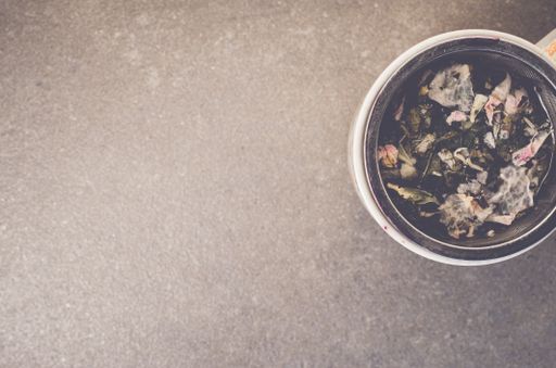 A top view of herbal tea in a cup on a rough-textured surface with copy space