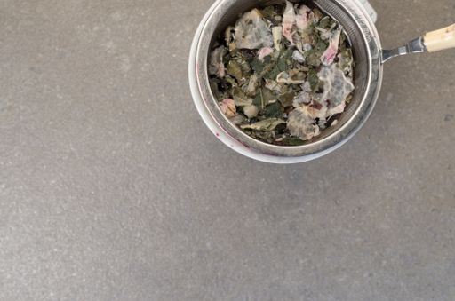 A top view of herbal tea in a cup on a rough-textured surface with copy space