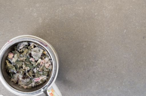 A top view of herbal tea in a cup on a rough-textured surface with copy space