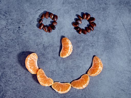A high angle shot of tangerine pieces and seeds shaped like a smiley face