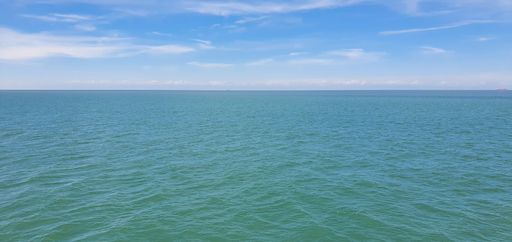An aerial panoramic view of blue cloudy sky over peaceful sea water in Florida