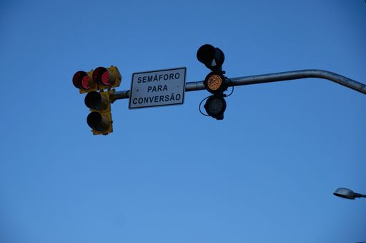 A low angle shot of a traffic light under the clear blue sky