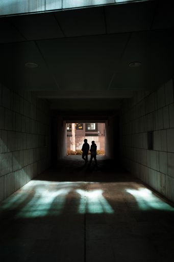 A vertical shot of two people walking under a tunnel in Beijing, China