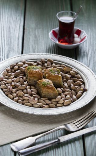 A vertical shot of Turkish Ramadan dessert baklava with pistachio on a wooden table