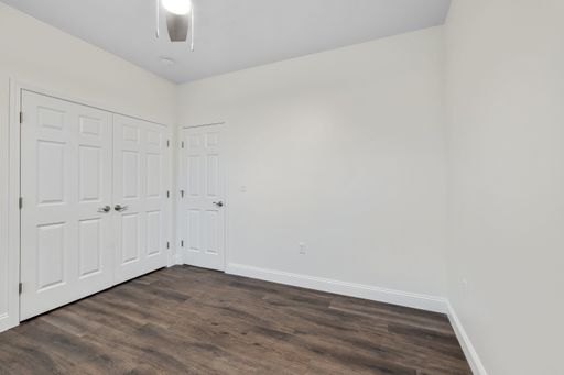 the interior of a parquet floor of a room with white walls and three doors
