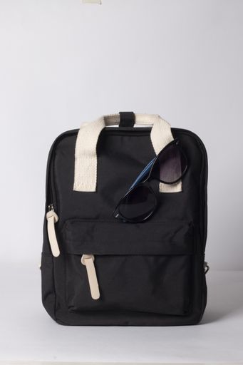 A vertical shot of a black travel backpack with sunglasses isolated on white background