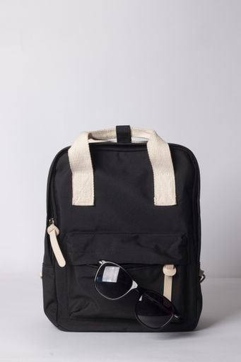 A vertical shot of a black travel backpack with sunglasses isolated on white background