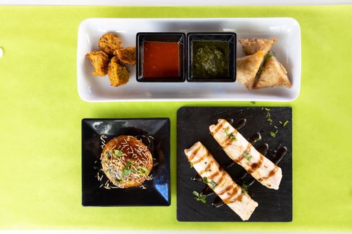 A top view of different Indian dishes on white table with green tablecloth
