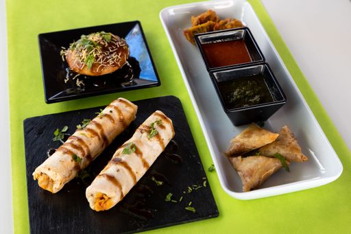 A closeup shot of different Indian dishes on white table with green tablecloth