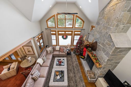 A high-angle shot of a modern living room with a fireplace. Custom-built house in the mountains.