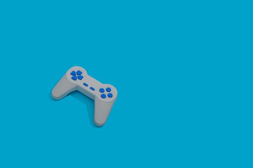An old retro game joypad controller isolated on a pastel blue background