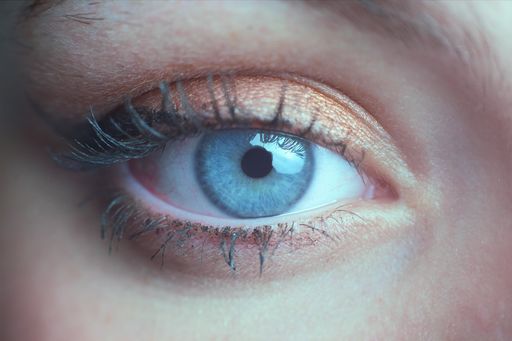 A macro photography of a beautiful blue-green eye of a woman with wing eyeliner