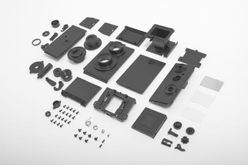 A high angle shot of twin-lens vintage open camera kit pieces isolated on a white background