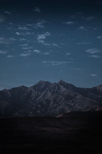 A vertical shot of mountains under a night sky