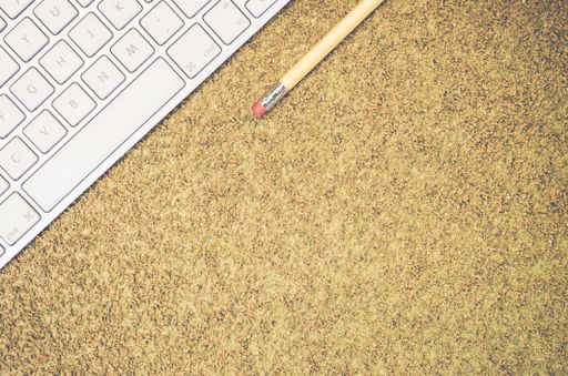 A top view of a computer keyboard on an office desk and pencil with copy space