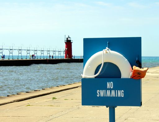 No swimming sign on pier with life preserver for water safety