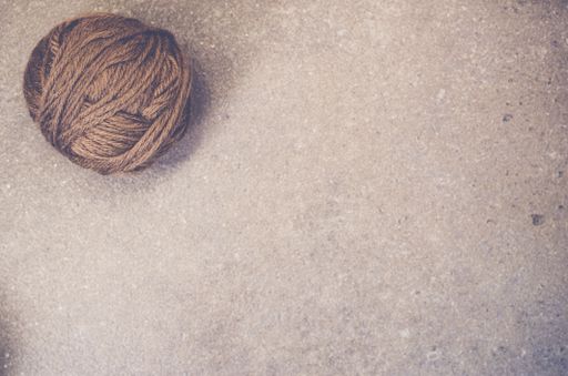 A high angle shot of a ball of yarn on a rough surface - copy space