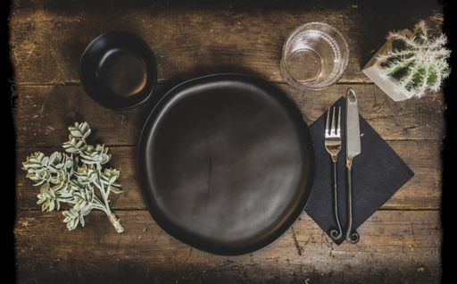An old wooden table with dishes and decorations on it under the lights