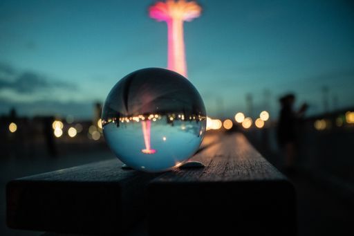 A shot of the colorful Parachute Jump in the Luna park of the Coney Island through a marble ball