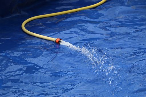 A closeup shot of a hose filling the inflatable pool