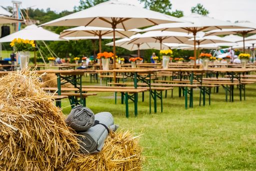 A selective focus shot of the picnic area with tables and umbrellas