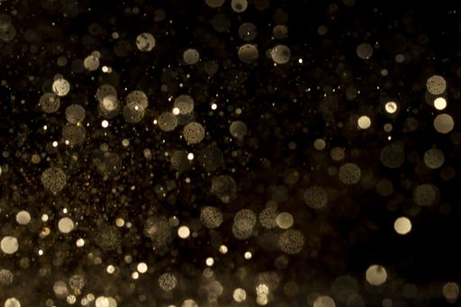 The shiny golden bokeh lights on a black background
