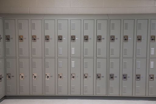 An array of metal lockers arranged in a row in front of a solid wall